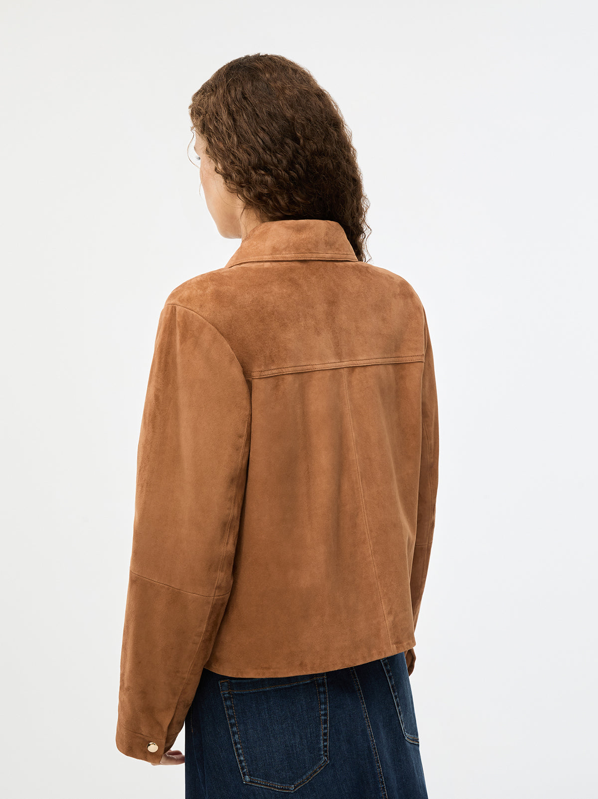 Person wearing a brown suede jacket on a white background rear view