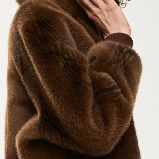 Brown fur coat with a blurred background sleeve detail