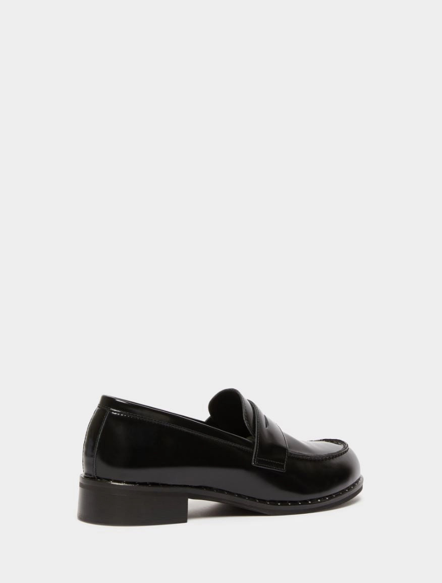 black leather loafers with small heel and metallic dot detailing along the edging form iblues rear view