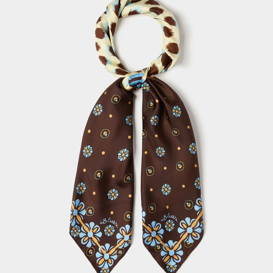 Brown floral patterned scarf with a white and brown checkered knot on a light gray background