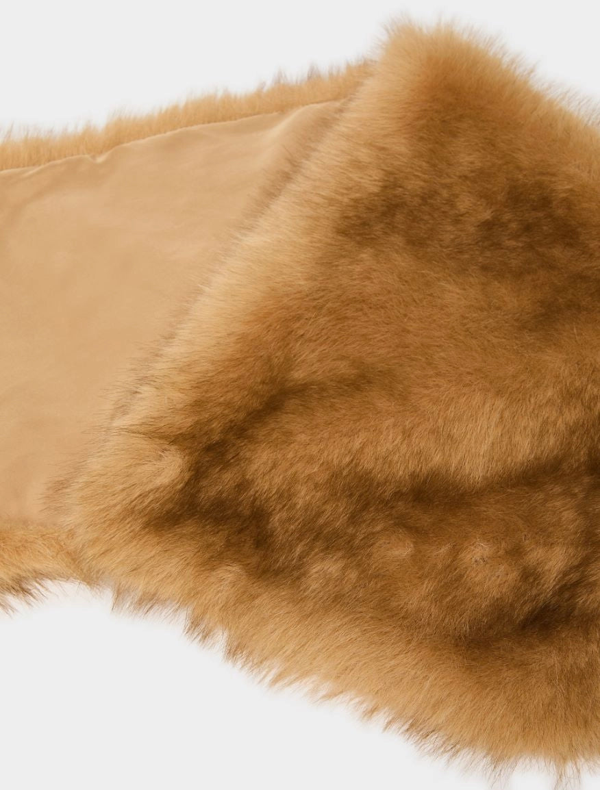 A close-up of a tan faux fur trim or collar with a smooth beige lining, shown against a plain white background.