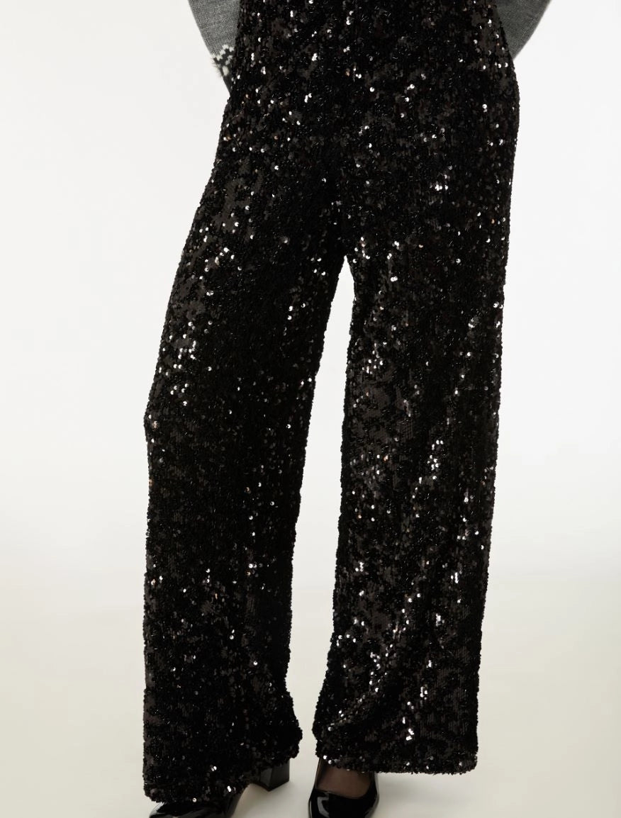 Black sequined wide-leg pants with a glittering silver sparkle effect, shown on a model from the waist down against a plain white background.