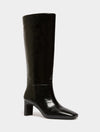 A single black knee-high boot with a glossy patent leather finish, a pointed toe, and a chunky block heel, shown against a plain light gray background.