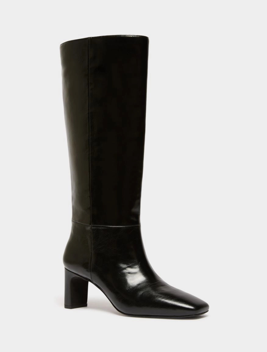 A single black knee-high boot with a glossy patent leather finish, a pointed toe, and a chunky block heel, shown against a plain light gray background.