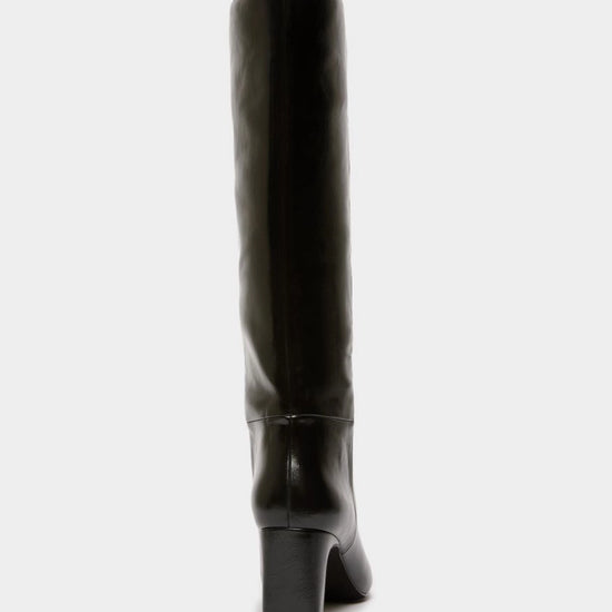 A black leather knee-high boot with a block heel, shown from a rear three-quarter view against a light gray background.