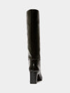A black leather knee-high boot with a block heel, shown from a rear three-quarter view against a light gray background.