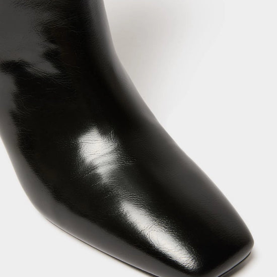 Close-up of a glossy black leather ankle boot with a square toe on a clean white background.