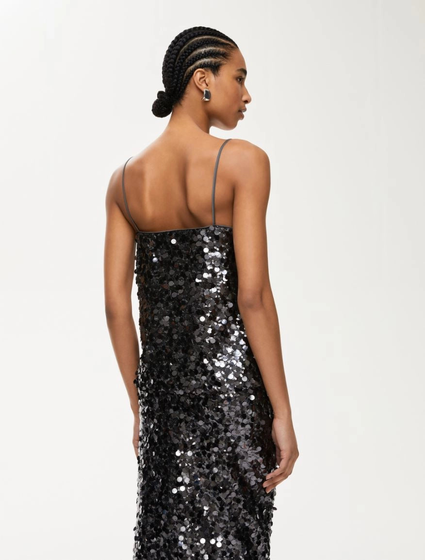 Rear view of woman wearing charcoal sequin top with matching skirt