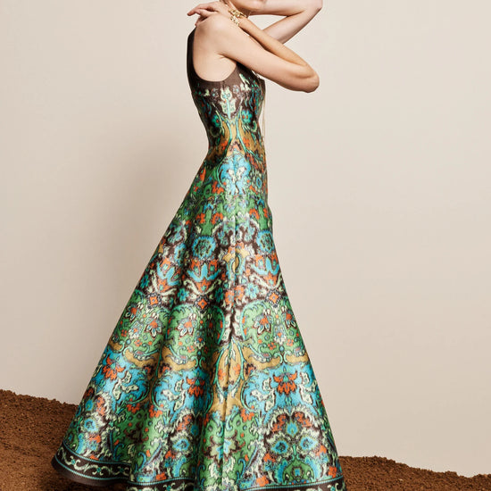 Woman wearing a colorful patterned dress against a neutral background