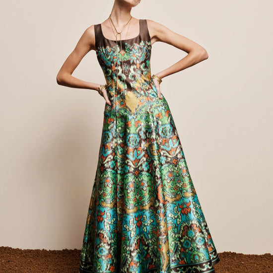 Woman wearing a colorful patterned dress on a plain background