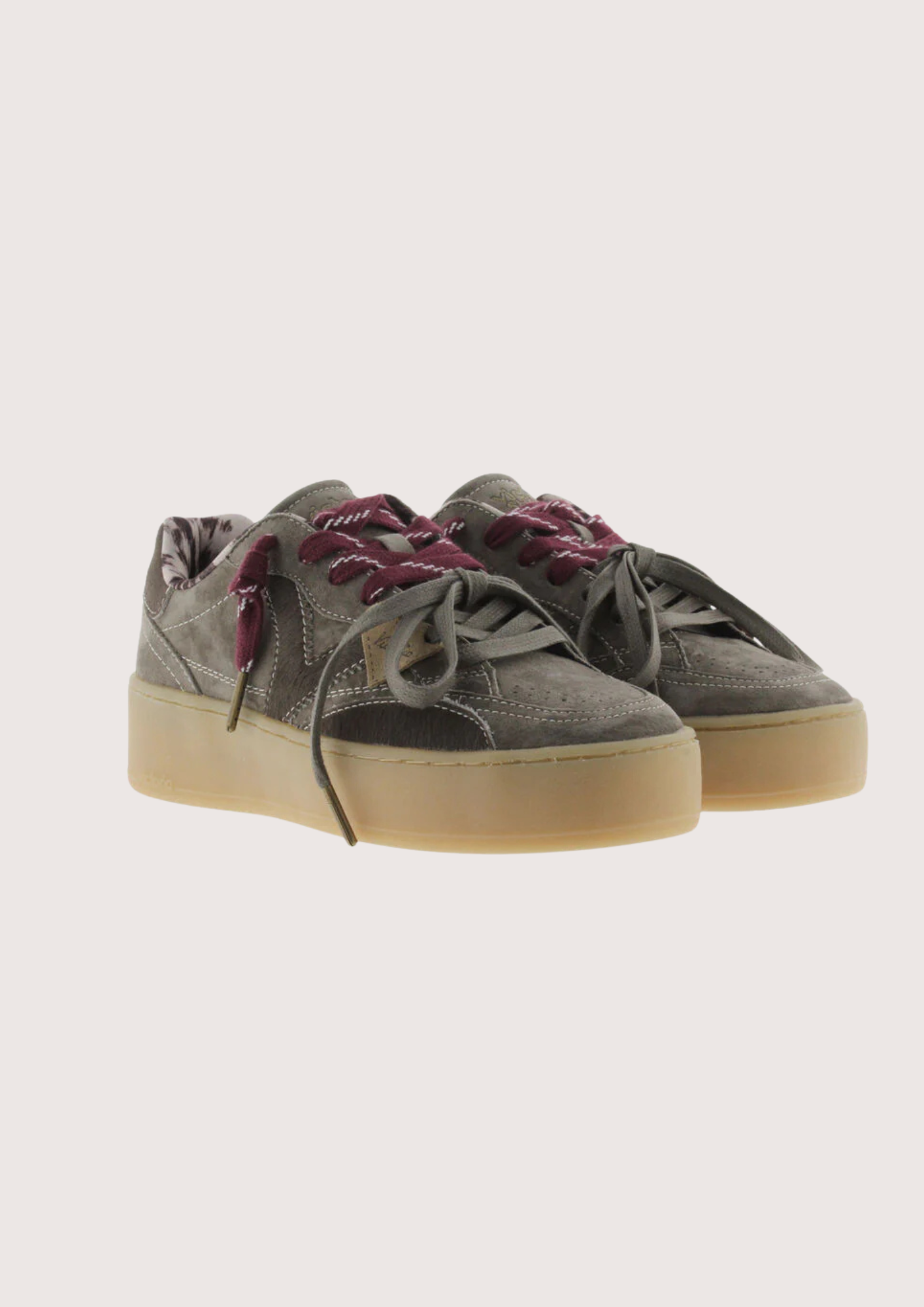 A low-top platform sneaker in dark gray suede and leather, featuring a thick beige gum sole, gray laces, and burgundy ribbon laces tied in a bow.