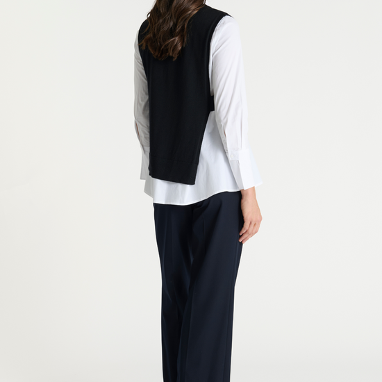 Black pullover vest with ribbed neck knit. Rear view.