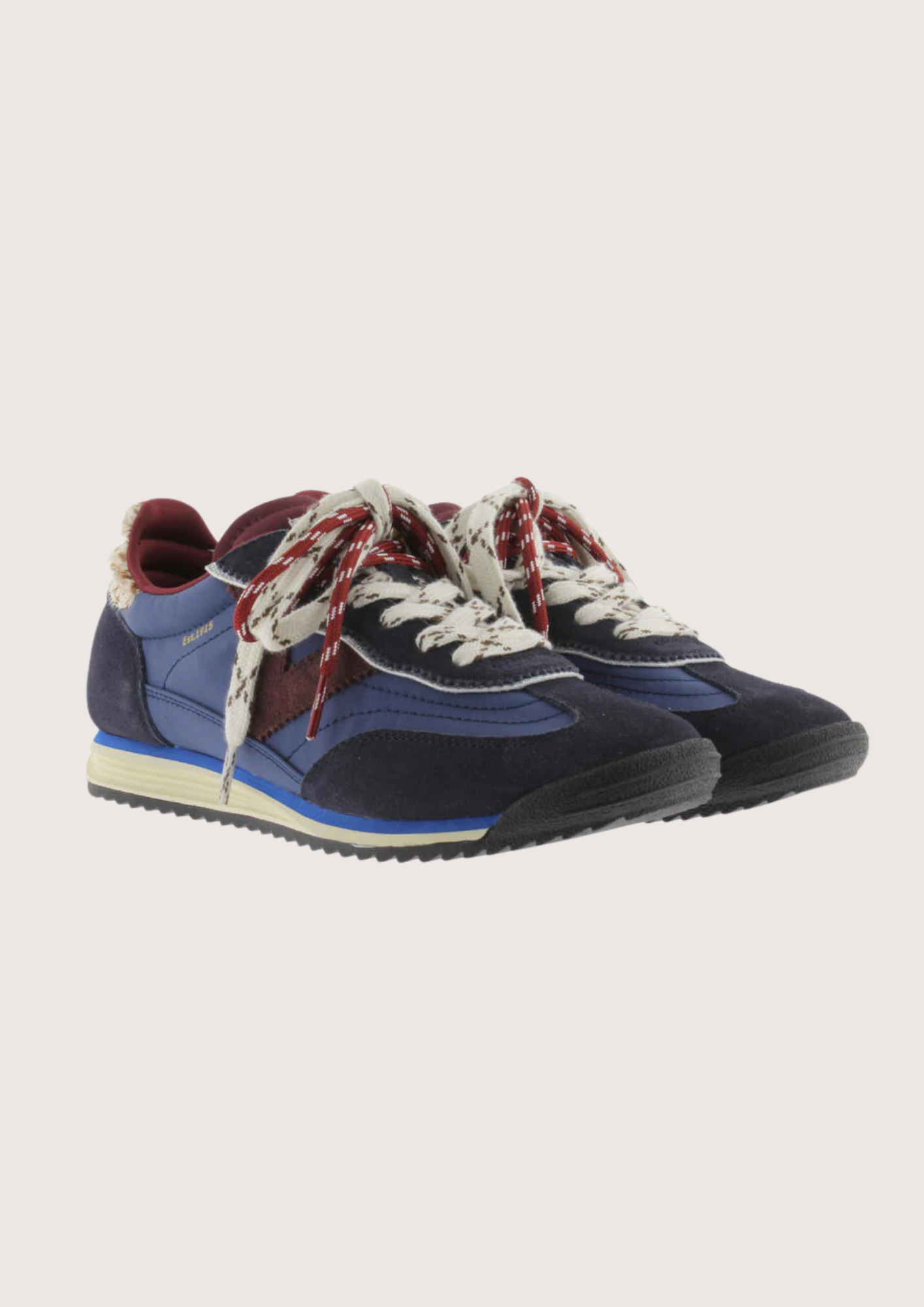 A low-top fashion sneaker, featuring navy blue suede and mesh panels, burgundy accents, patterned white and burgundy laces, and a cream midsole, shown against a plain light gray background.