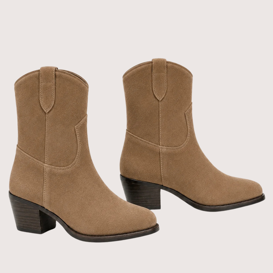 A pair of women's mid-calf western-style boots in tan suede, featuring a stacked block heel and dark sole, shown against a light beige background.
