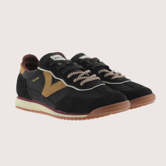 A black suede and mesh low-top sneaker with tan side panels, burgundy lining, and a cream midsole, shown from a side profile on a light gray background.