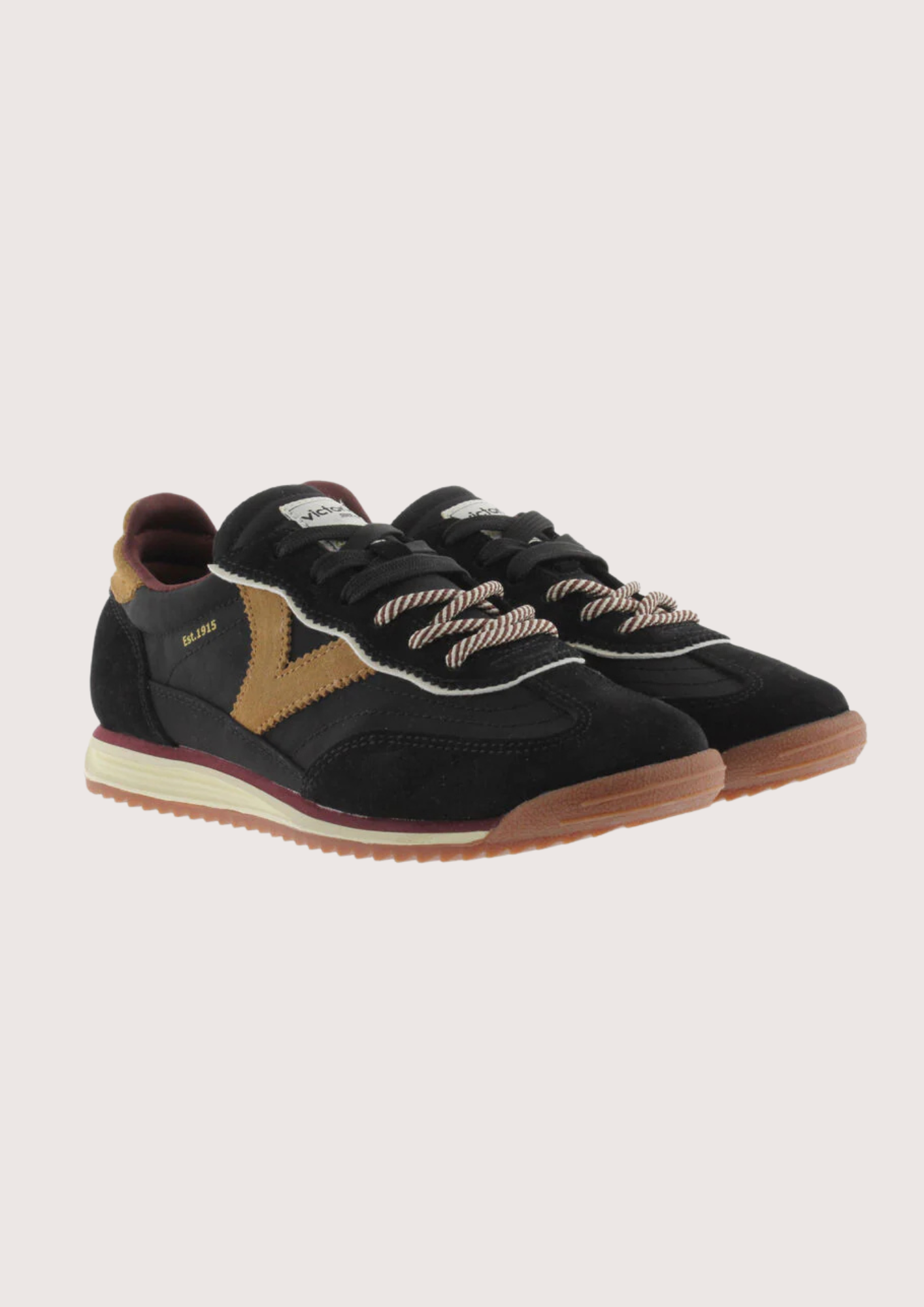 A black suede and mesh low-top sneaker with tan side panels, burgundy lining, and a cream midsole, shown from a side profile on a light gray background.