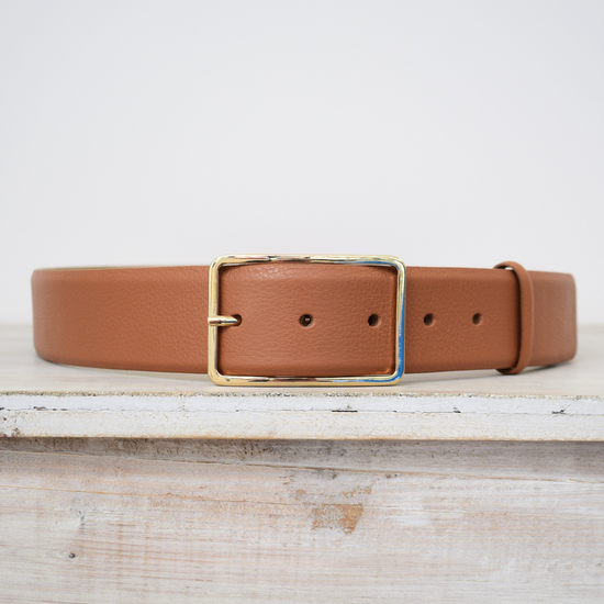 Wide tan belt with thin gold buckle 