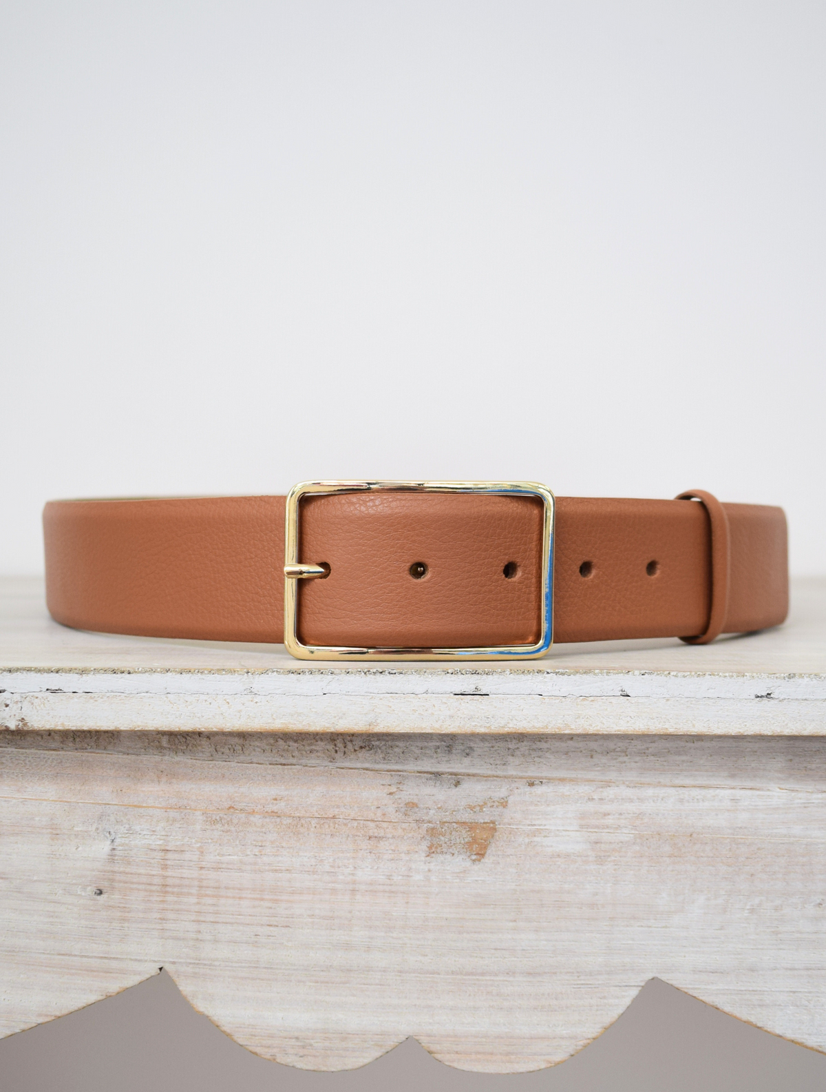 Wide tan belt with thin gold buckle 