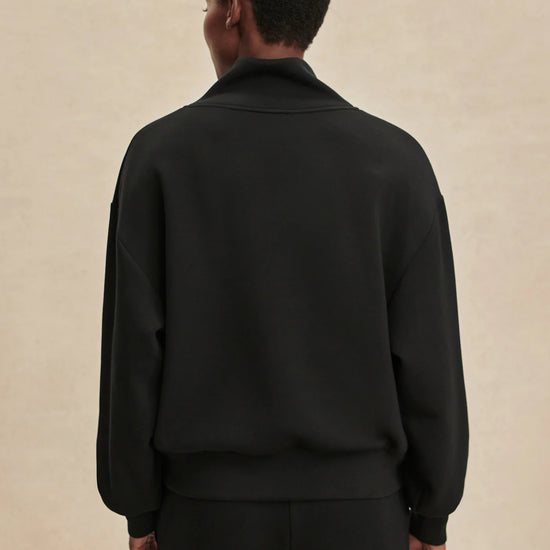 Quarter zip and slightly cropped black sweat top with shawl collar and V neckline from varley rear view