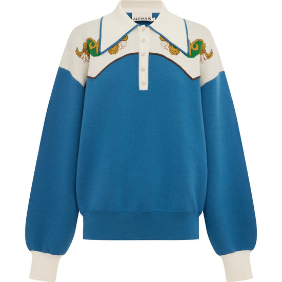 A blue and cream color-blocked knit sweater with a polo-style collar, featuring embroidered green and gold details across the yoke and ribbed cuffs.