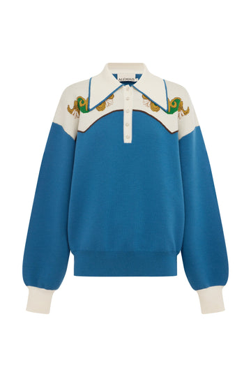 A blue and cream color-blocked knit sweater with a polo-style collar, featuring embroidered green and gold details across the yoke and ribbed cuffs.