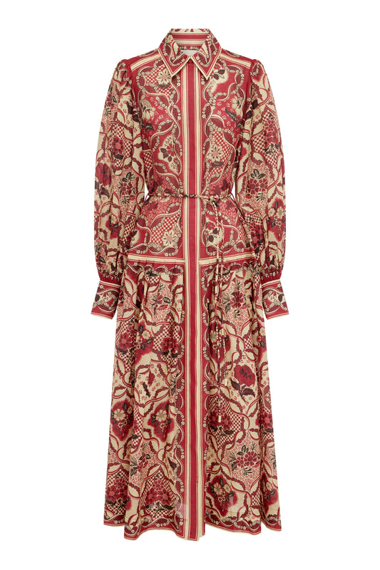A long-sleeve collared maxi shirt dress with a red, beige, and black botanical pattern, featuring a self-tie waist belt, shown against a plain white background.