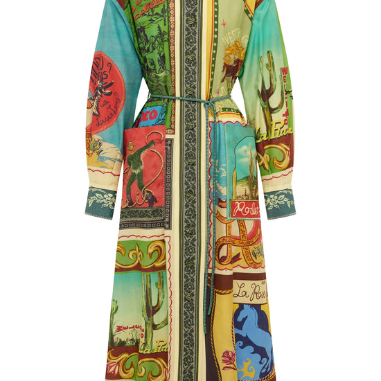 A long-sleeved, collared wrap-style coat featuring a vibrant, multicolor patchwork print with desert, architectural, and scenic motifs, set against a plain white background.