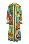 A long-sleeved, collared wrap-style coat featuring a vibrant, multicolor patchwork print with desert, architectural, and scenic motifs, set against a plain white background.