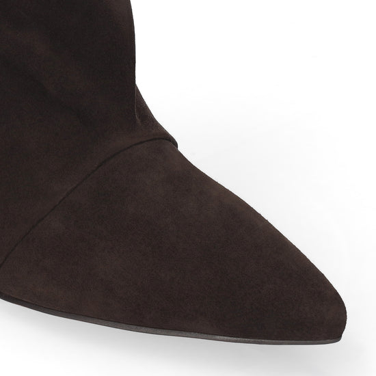 Close-up of a dark brown suede boot with a pointed toe on a white background.