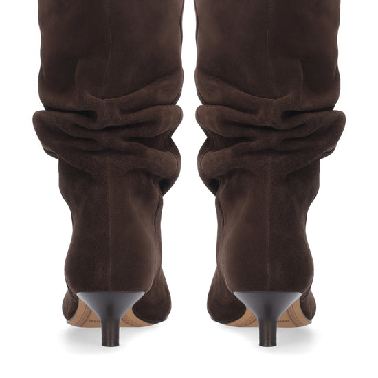 A pair of dark brown suede slouchy mid-calf boots with pointed toes and slim dark heels, shown from the back on a white background.