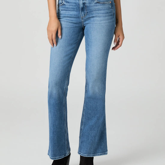 Blue jeans by Paige worn by a person on a white background