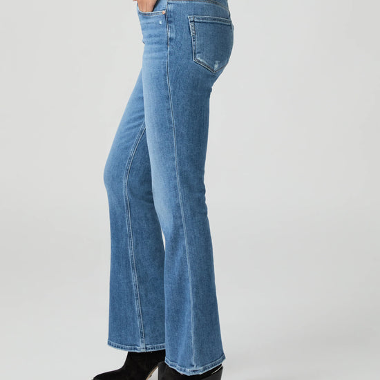 Blue jeans by Paige worn by a person on a white background side view