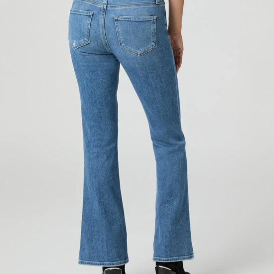 Blue jeans by Paige worn by a person on a white background rear view
