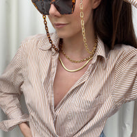 model shot with sunglasses chain and the snake chain layered with another chunky gold chain