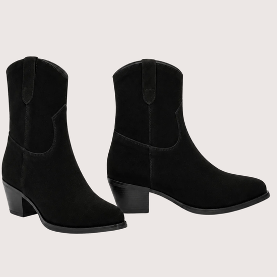 A pair of black suede western-style ankle boots with low block heels, shown against a solid off-white background.