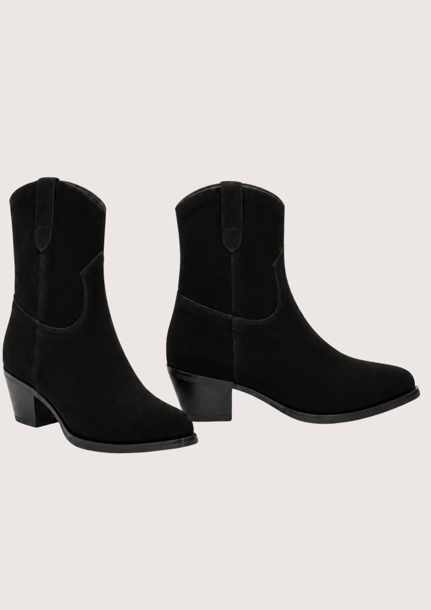 A pair of black suede western-style ankle boots with low block heels, shown against a solid off-white background.