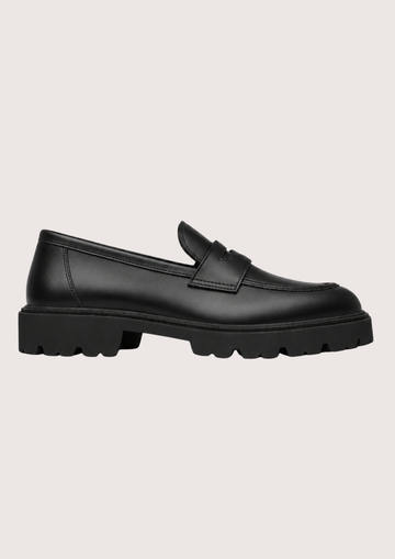 black leather penny loafer with black sole on a light background product shot 