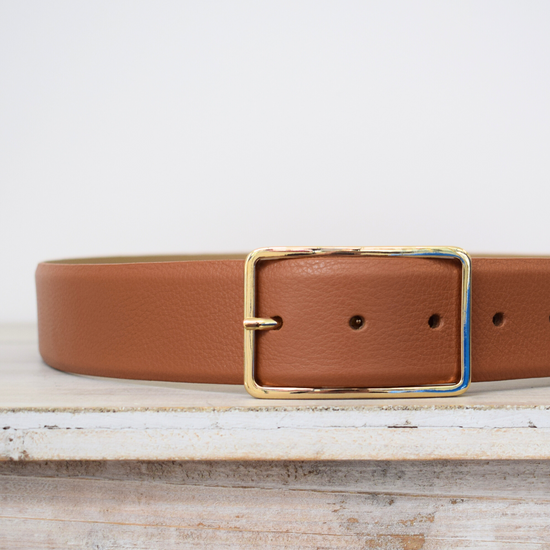 Wide tan belt with thin gold buckle 