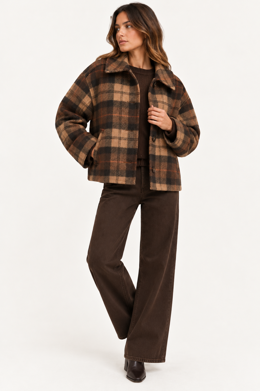 A woman modeling a brown and tan plaid cropped jacket with a wide collar, paired with dark brown wide-leg pants and dark brown boots, against a plain white studio background.