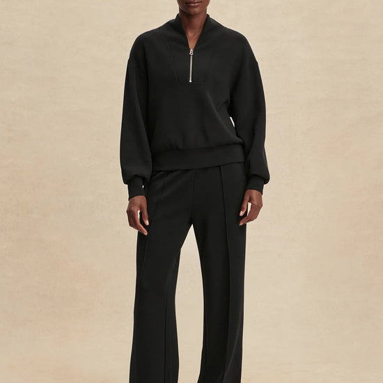 Quarter zip and slightly cropped black sweat top with shawl collar and V neckline from varley model shot