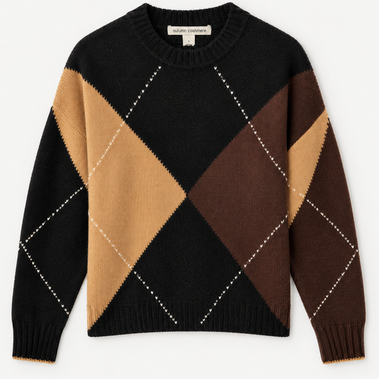 A long-sleeve knit sweater with a diamond argyle pattern in black, tan, and brown, featuring thin white dotted lines forming diagonal diamonds, shown flat on a light gray background.