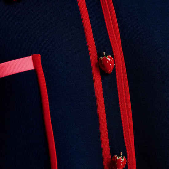 close up of strawberry buttons on navy jumper