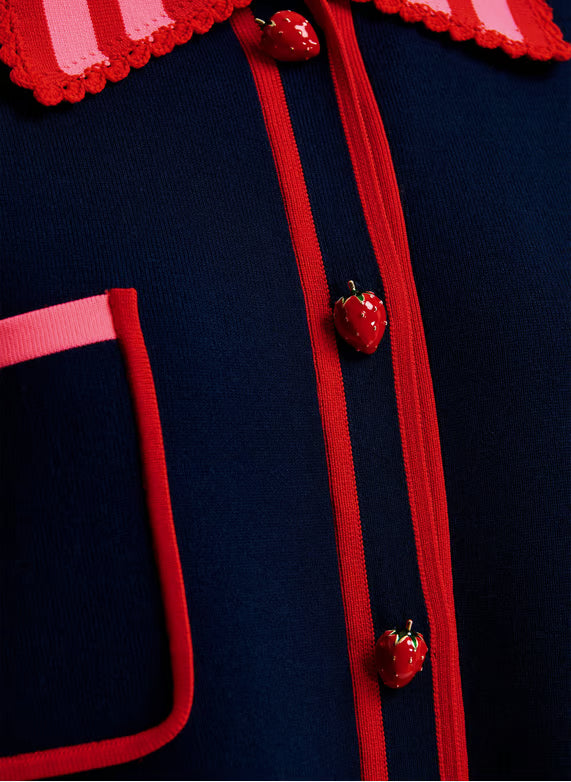 close up of strawberry buttons on navy jumper