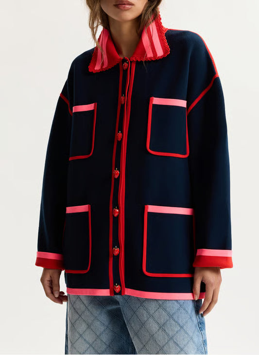 Navy jacket with red accents worn by a person on a light gray background