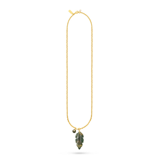 A delicate gold chain necklace featuring a small gold bead charm and a leaf-shaped pendant with green and gold detailing, displayed on a clean white background.