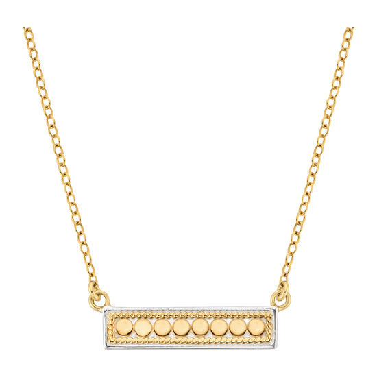 Gold necklace with a rectangular pendant featuring round elements on a white background