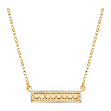 Gold necklace with a rectangular pendant featuring round elements on a white background