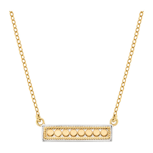 Gold necklace with a rectangular pendant featuring round elements on a white background