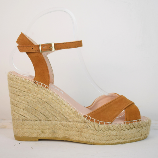 Wedge sandals with a tan cross cover on the toes