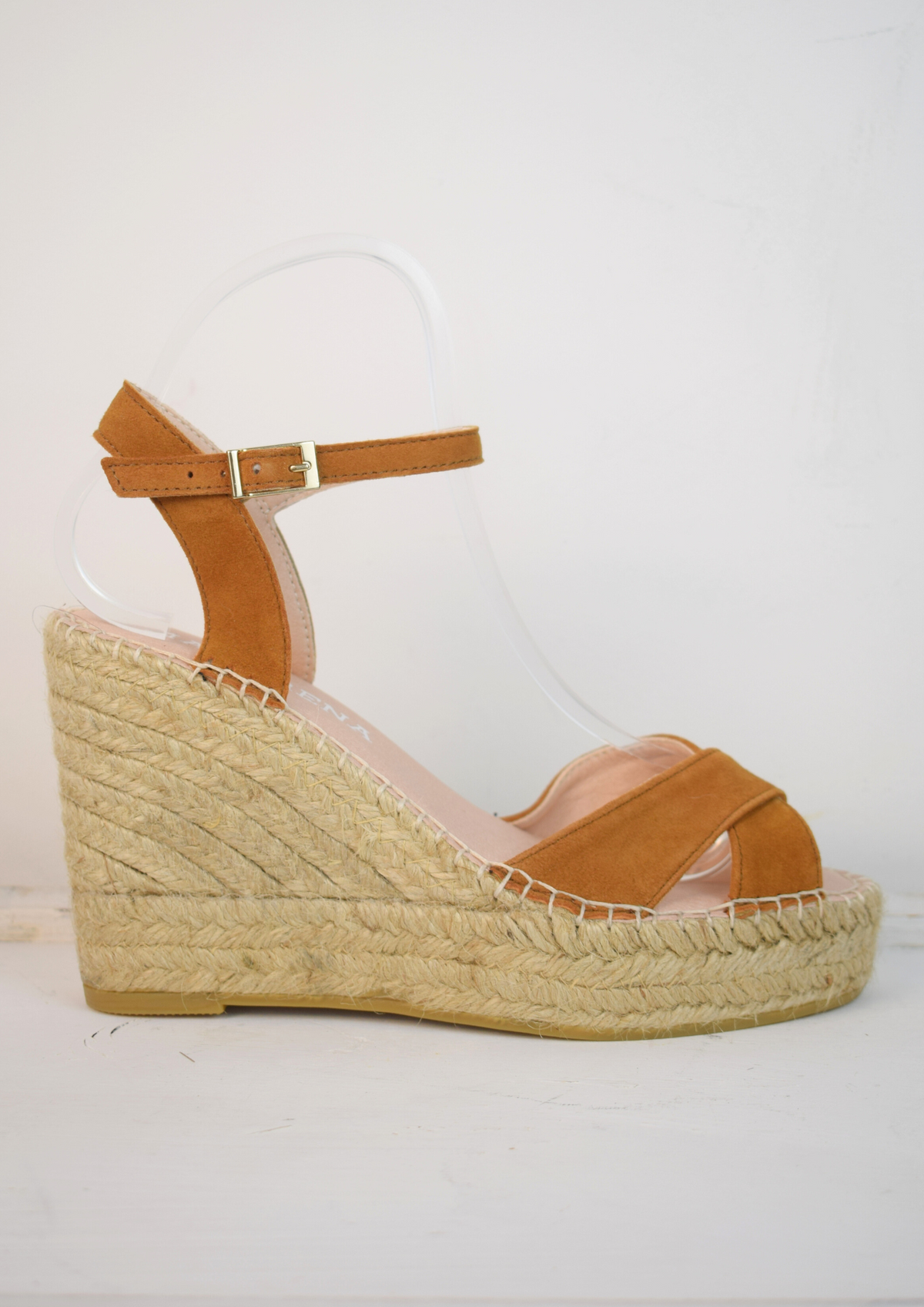 Wedge sandals with a tan cross cover on the toes